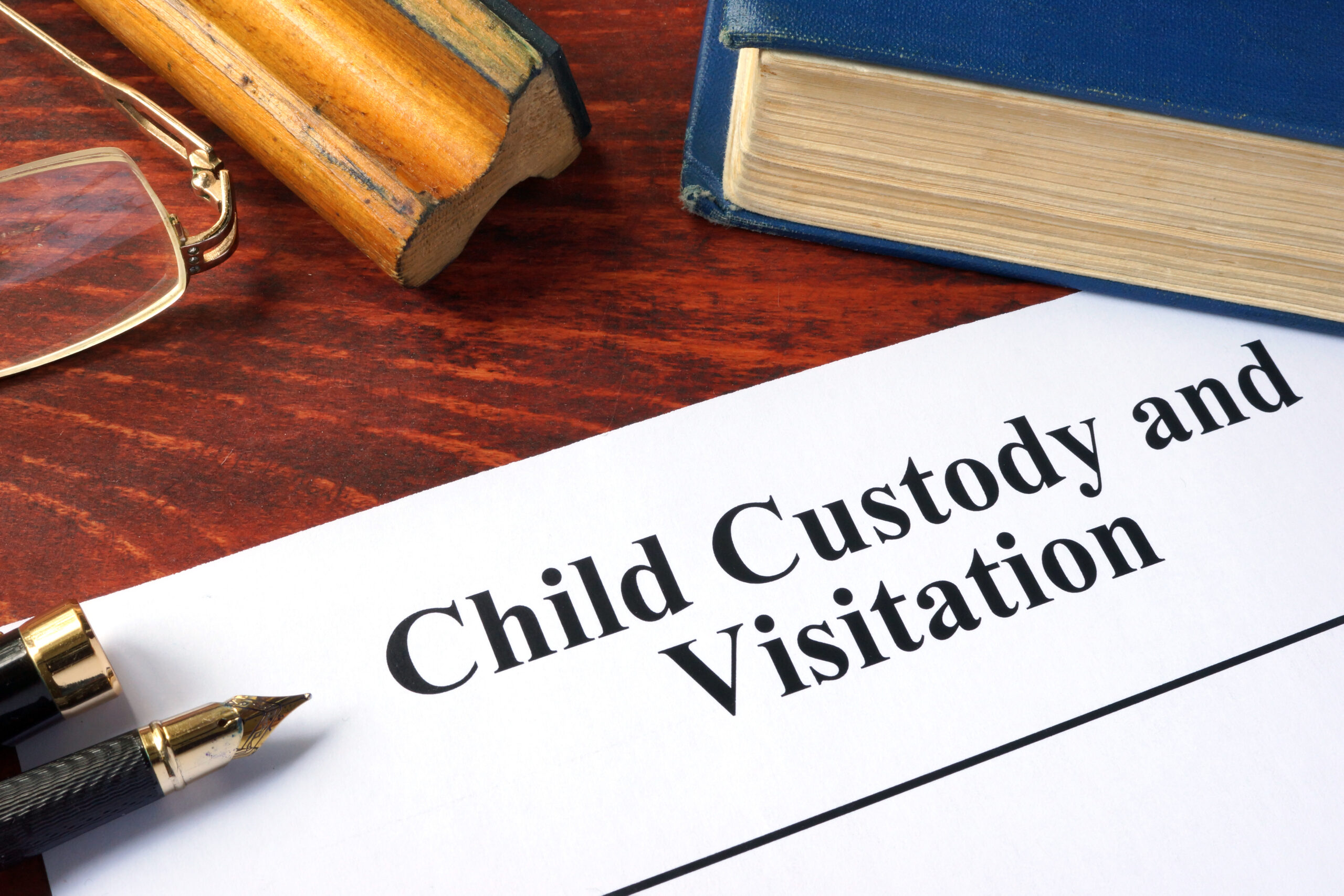 Child Custody and Visitation written on a paper and a book.